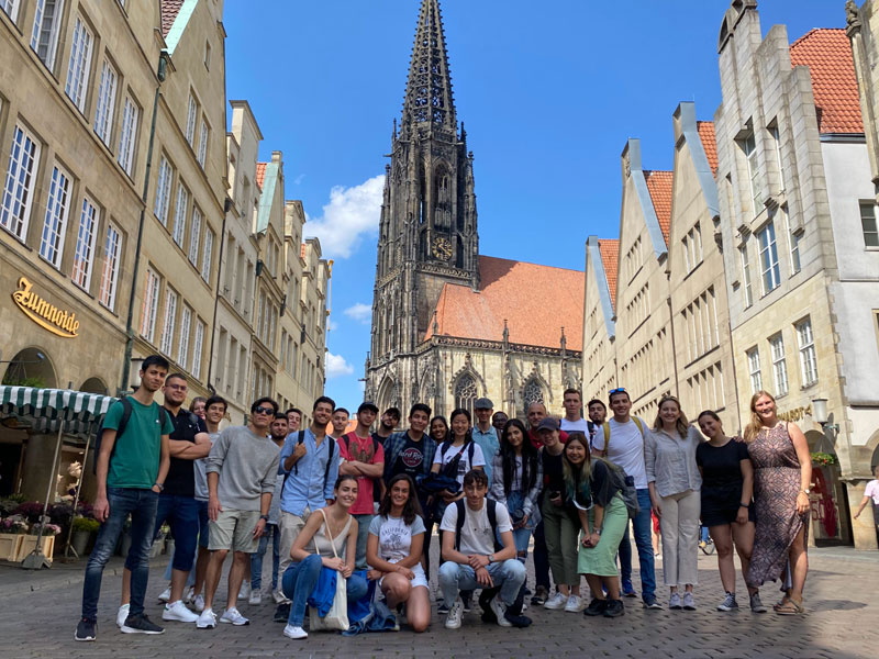 Gruppe internationaler Sprachschülerinnen und Sprachschüler auf dem Prinzipalmarkt in Münster vor der Lambertikirche