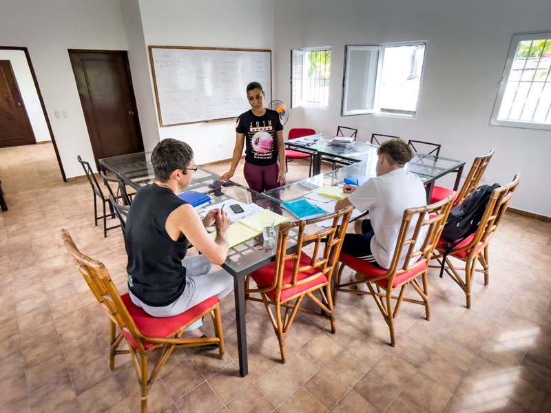Cours d’espagnol en petit groupe à Sosúa avec enseignant et participants dans une salle de classe lumineuse