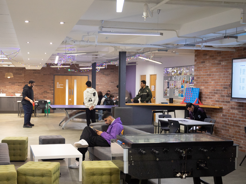 Zona común de la escuela de idiomas Bayswater Bournemouth, con sala de estar, juegos y alumnos