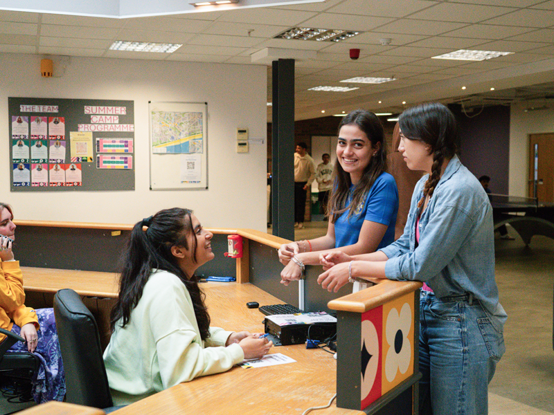Zona de recepción de la escuela de idiomas Bayswater Bournemouth, donde se puede ver un intercambio cordial entre los alumnos y el personal
