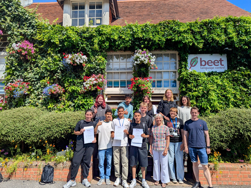Begrünte Fassade des Beet Language Centre in Bournemouth mit blühenden Blumen und Gruppenfoto der Lernenden