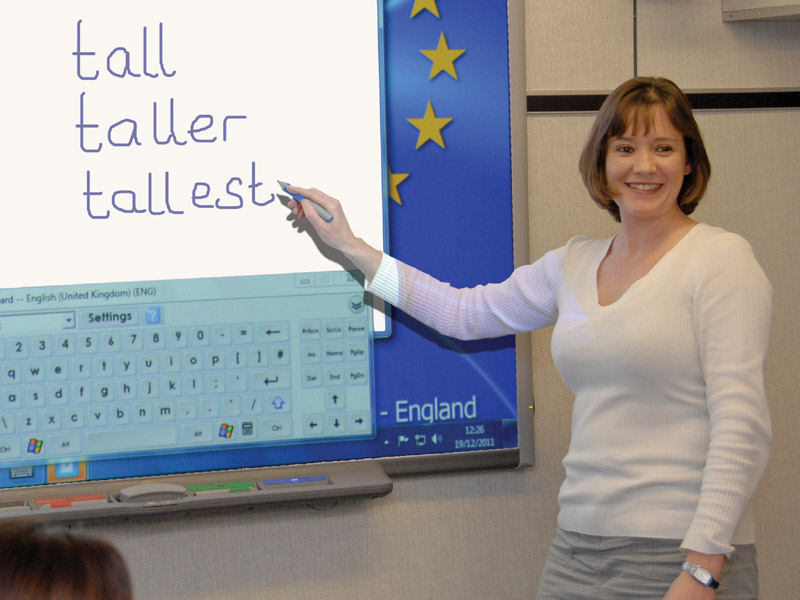 Englischlehrerin erklärt Adjektive am Smartboard im Unterricht des ETC International College Bournemouth.