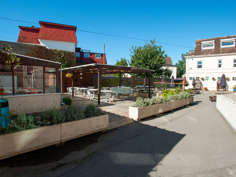 Gemütlicher Außenbereich mit Sitzplätzen und Pflanzen an der Sprachschule ETC Bournemouth.