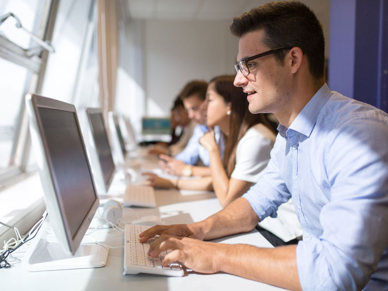 Englischschüler arbeiten konzentriert am Computerraum der Kaplan Bournemouth.
