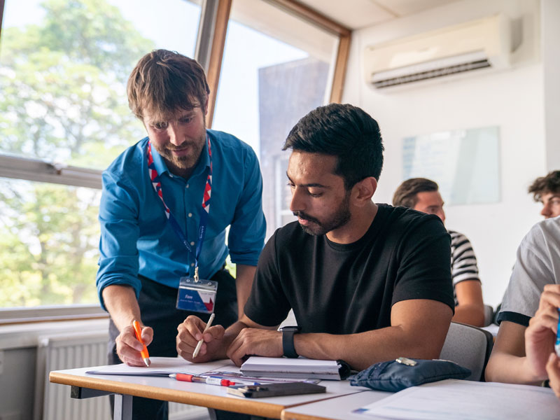 Lehrer unterstützt Schüler individuell im Englischunterricht bei Kaplan Bournemouth.