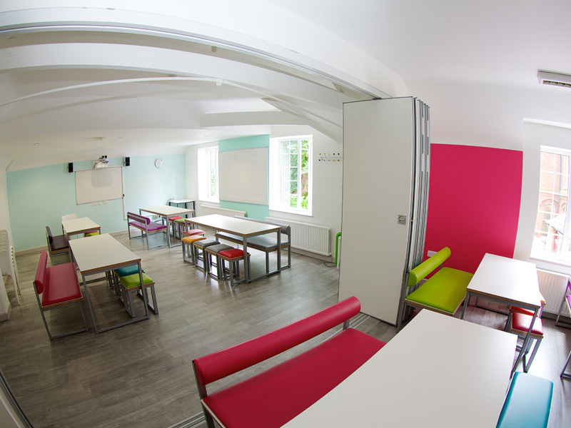 Helles Klassenzimmer mit bunten Möbeln in der Kings Sprachschule Bournemouth.