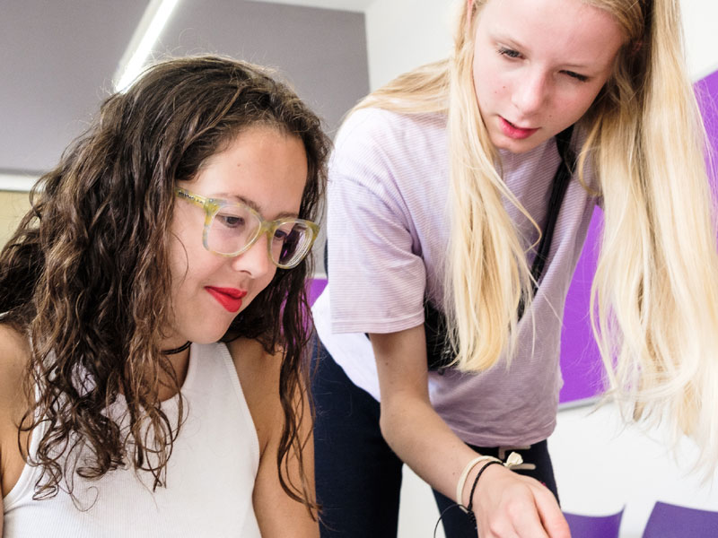 Zwei Schülerinnen vertiefen Grammatikübungen im Englischkurs