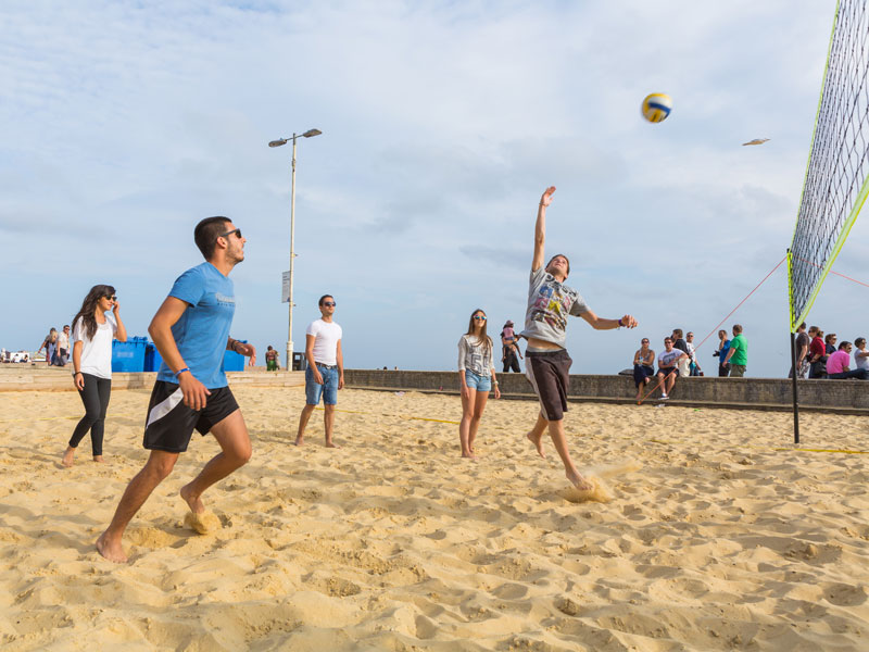 Sprachschüler spielen Beachvolleyball während ihrer Sprachreise