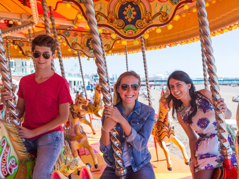 Sprachreiseteilnehmende genießen Freizeit auf dem Karussell am Strand