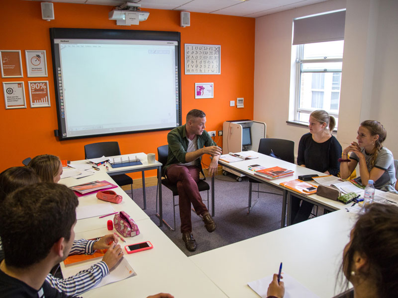 Lehrkraft erklärt Sprachübungen im Englischkurs mit interaktivem Austausch