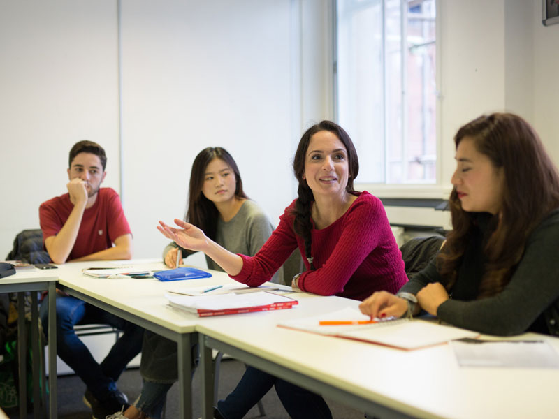 Gruppe Erwachsener im Englischkurs beim Sprechen und Diskutieren