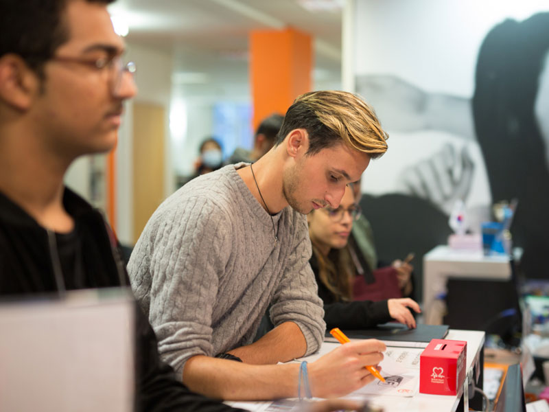 Sprachreisende beim Ausfüllen von Unterlagen in der Sprachschule