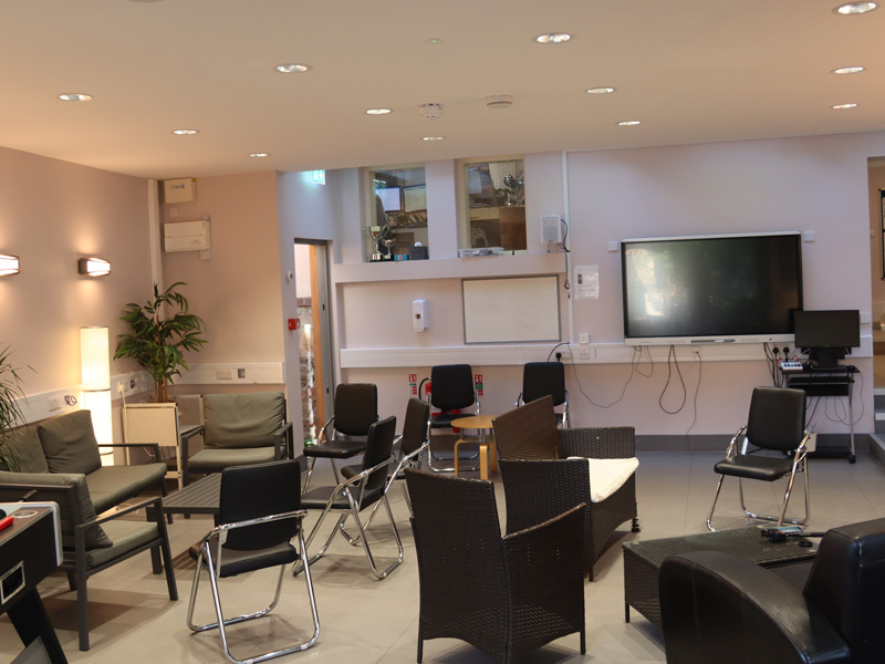 Aufenthaltsraum der Schule mit Fernseher, Sofas und Sitzgelegenheiten für Lernpausen