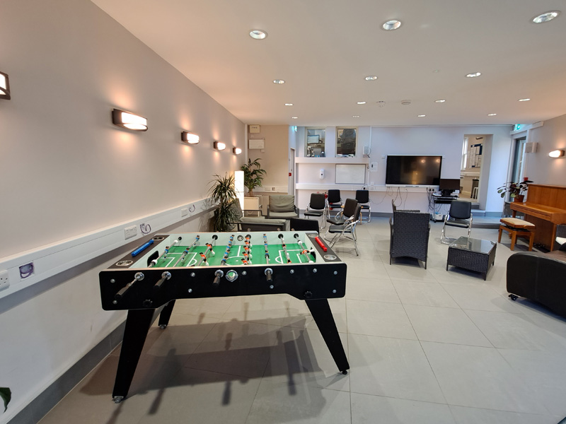 Freizeitbereich mit Tischfußball, Klavier und Sitzgruppen für gemeinsames Entspannen
