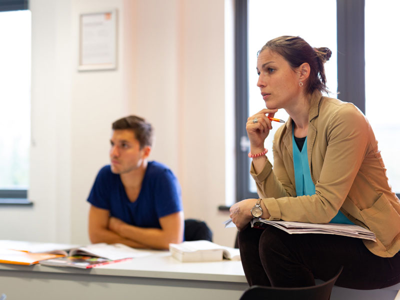 Lehrerin erklärt Grammatik im Englischkurs für Erwachsene