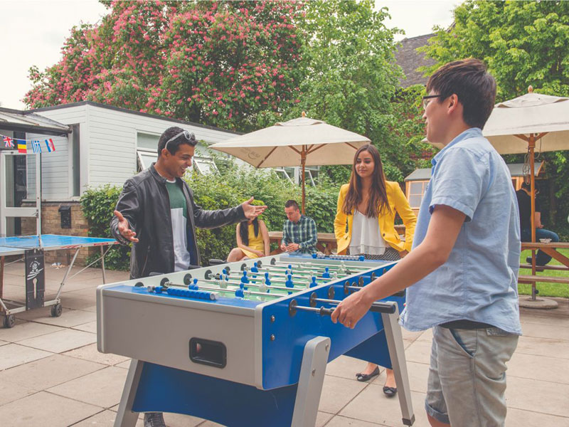 Schüler spielen Tischfußball auf dem Schulgelände