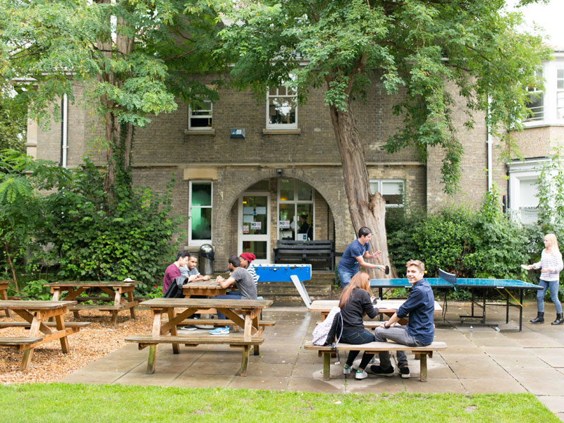 Gartenbereich der Schule mit Sitzgelegenheiten und Freizeitangeboten