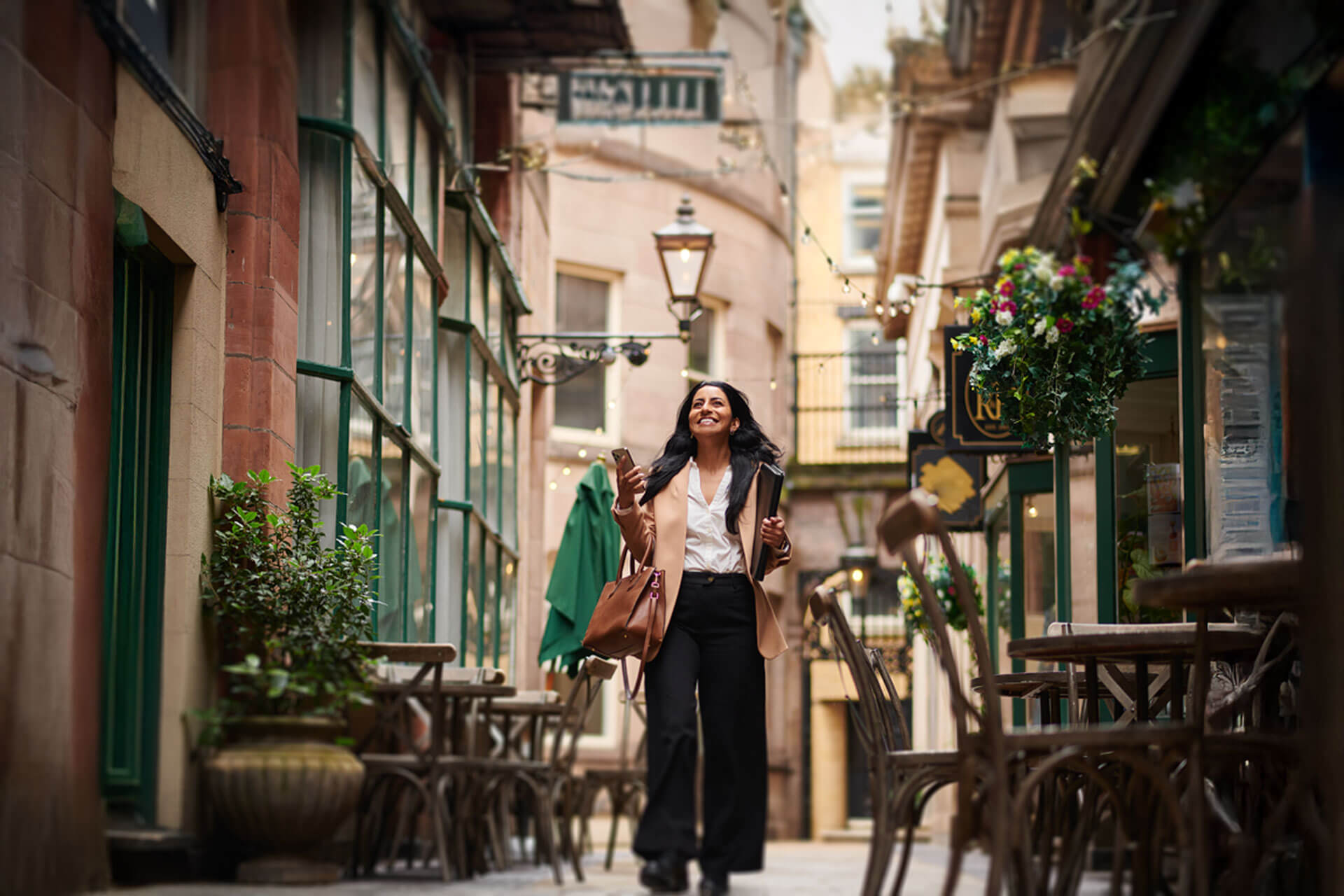 Teilnehmerin einer Englisch Sprachreise erkundet fröhlich kleine Gasse nach dem Sprachkurs
