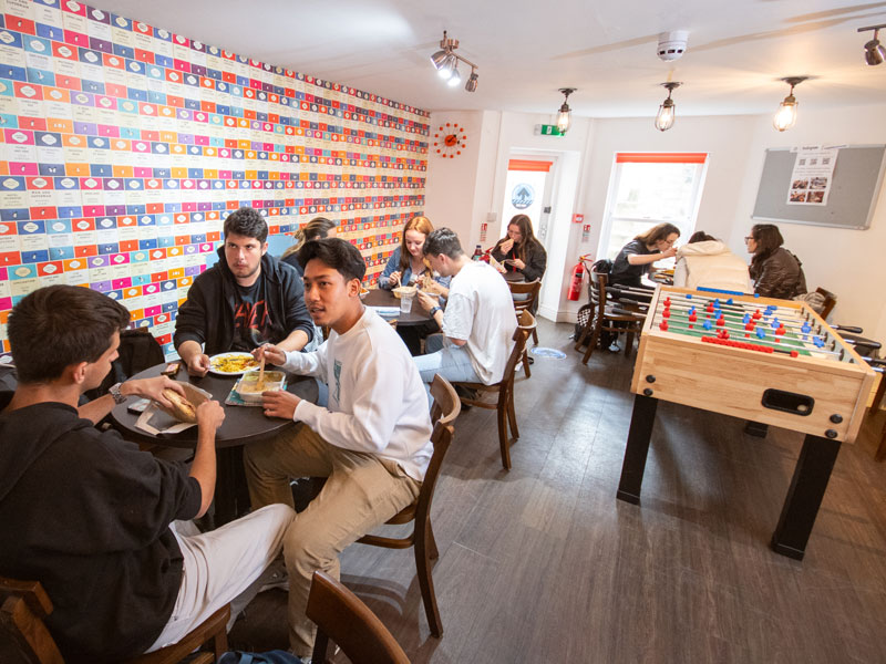 nternationale Sprachschülerinnen und Sprachschüler beim Mittagessen im Gemeinschaftsraum der St Giles Cambridge