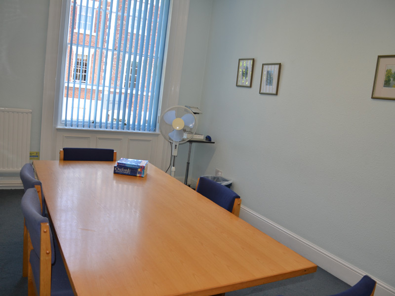 Aufenthaltsraum mit roten Stühlen und Tischen in der ELC Sprachschule Chester