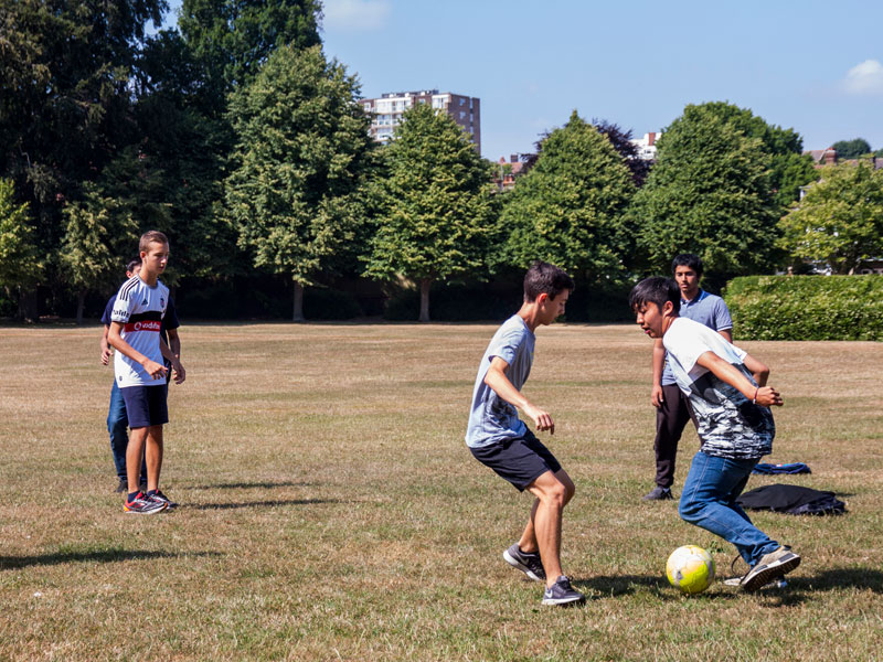 Freizeitaktivität im Park bei der ELC Sprachschule Eastbourne mit Fußballspielenden
