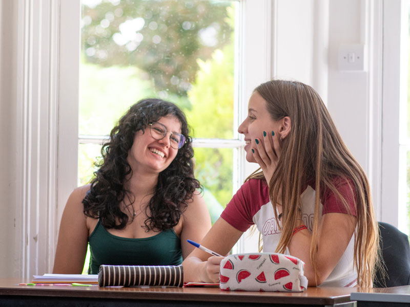 Zwei Teilnehmerinnen lachen im Klassenzimmer der St. Giles Sprachschule Eastbourne