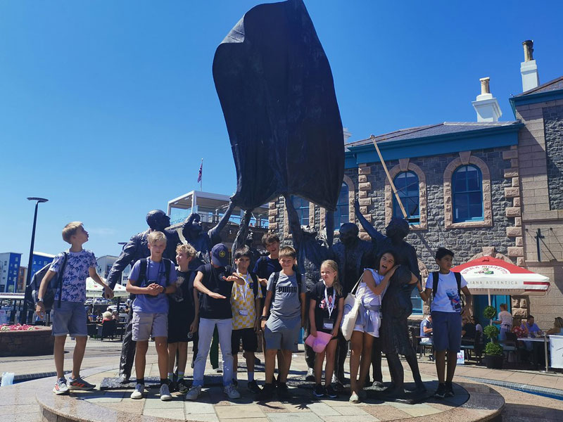 Jugendliche Sprachschülergruppe besichtigt die „Liberation Statue“ in St. Helier auf Jersey bei sonnigem Wetter