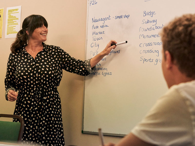 Lehrerin erklärt englische Vokabeln an der Tafel im Klassenraum der St Brelade’s College Jersey