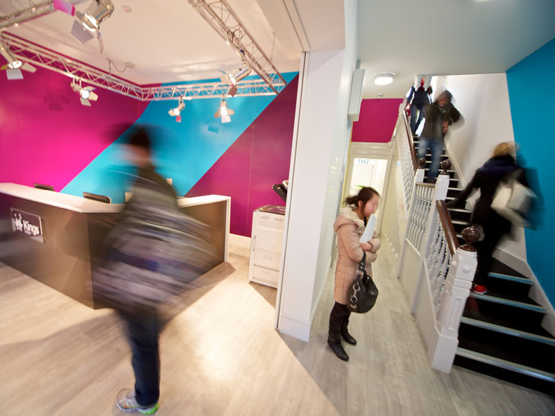 Heller Eingangsbereich mit bunten Wänden und Treppenaufgang der Kings London Beckenham Schule