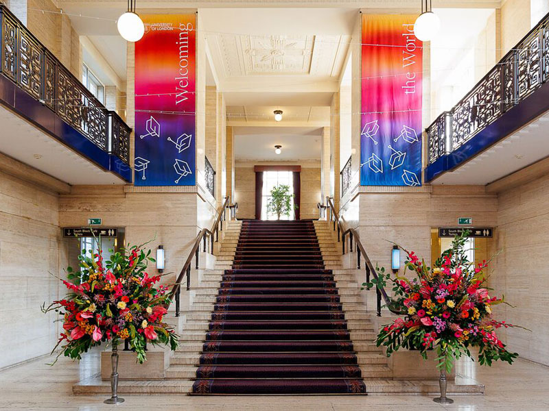 Eingangshalle der LSE Sprachschule London mit breiter Treppe und farbenfrohen Bannern