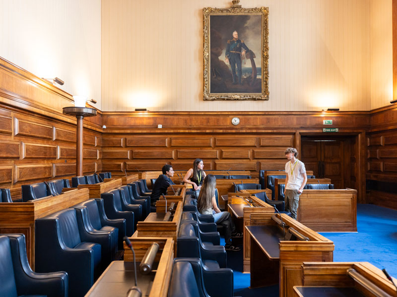 Sprachschüler sitzen im historischen Seminarraum der LSE London während einer Unterrichtsbesprechung