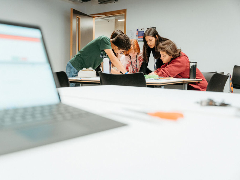 Kleingruppe Jugendlicher arbeitet gemeinsam an einer Aufgabe im Unterricht