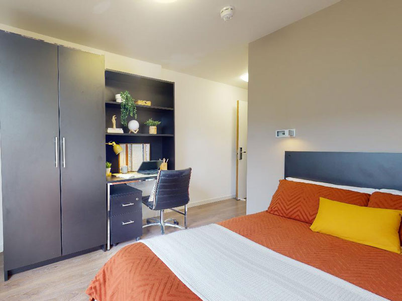Chambre individuelle avec lit, bureau et espace de rangement à la résidence iQ London City