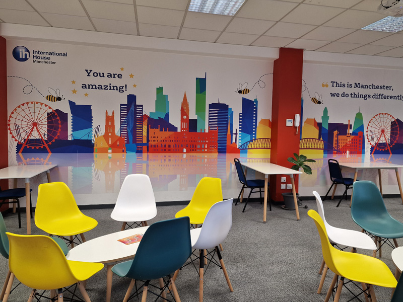 Aufenthaltsraum der International House Manchester mit bunter Wandgestaltung und modernen Sitzbereichen
