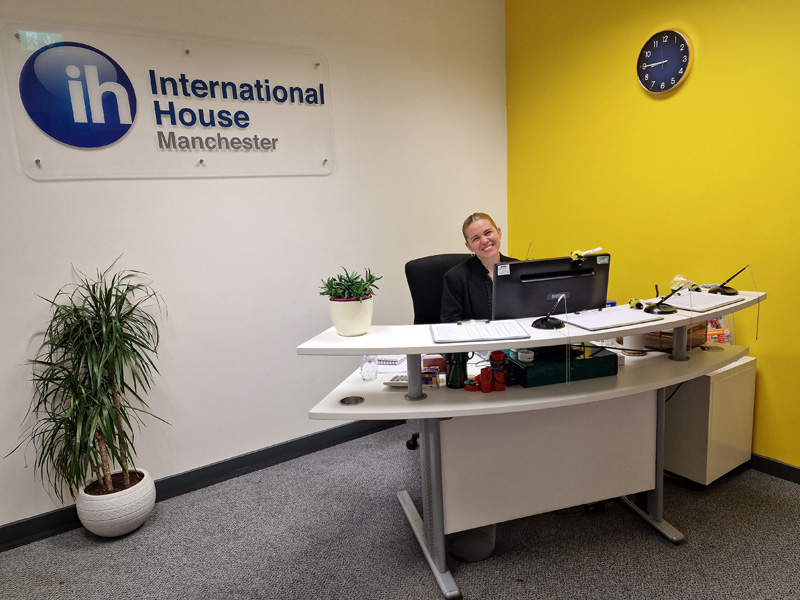 Empfangsbereich der International House Manchester mit freundlicher Mitarbeiterin am Schreibtisch