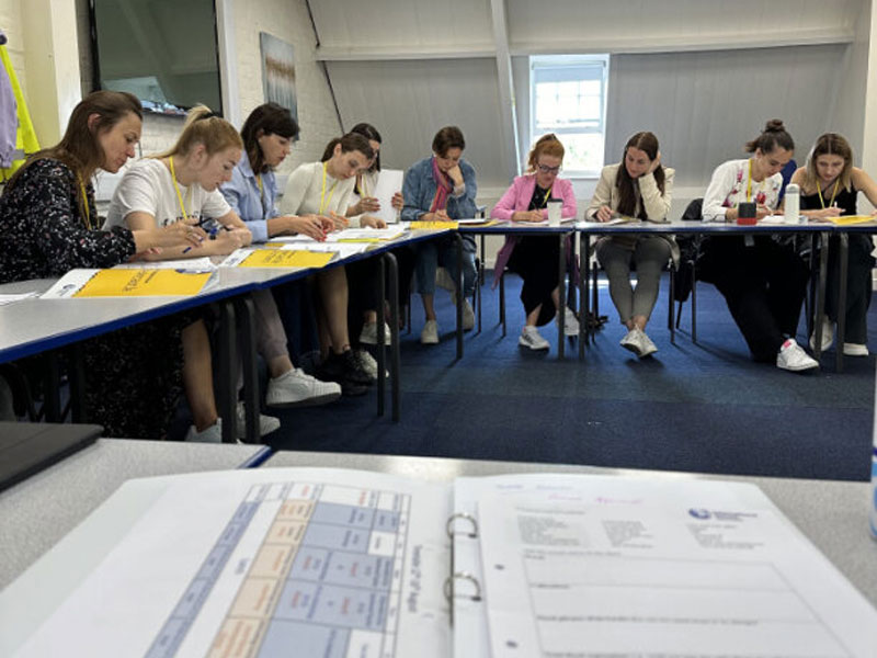 Teilnehmende eines Intensivsprachkurses schreiben konzentriert im Klassenzimmer der International House Newcastle