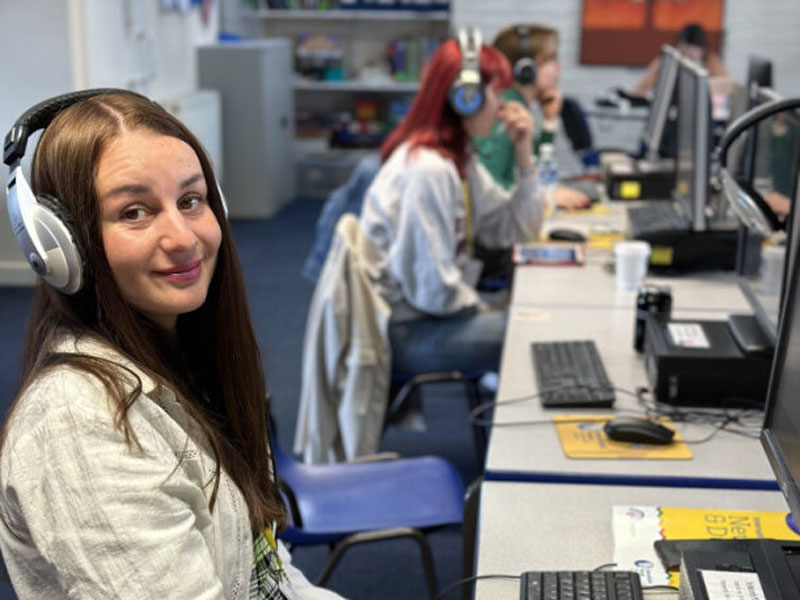Sprachschülerin der International House Newcastle arbeitet mit Kopfhörern an einem Computer