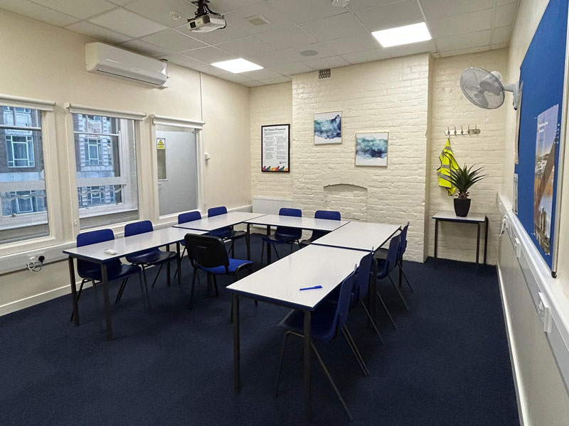 Heller Unterrichtsraum der International House Newcastle mit U-förmig angeordneten Tischen