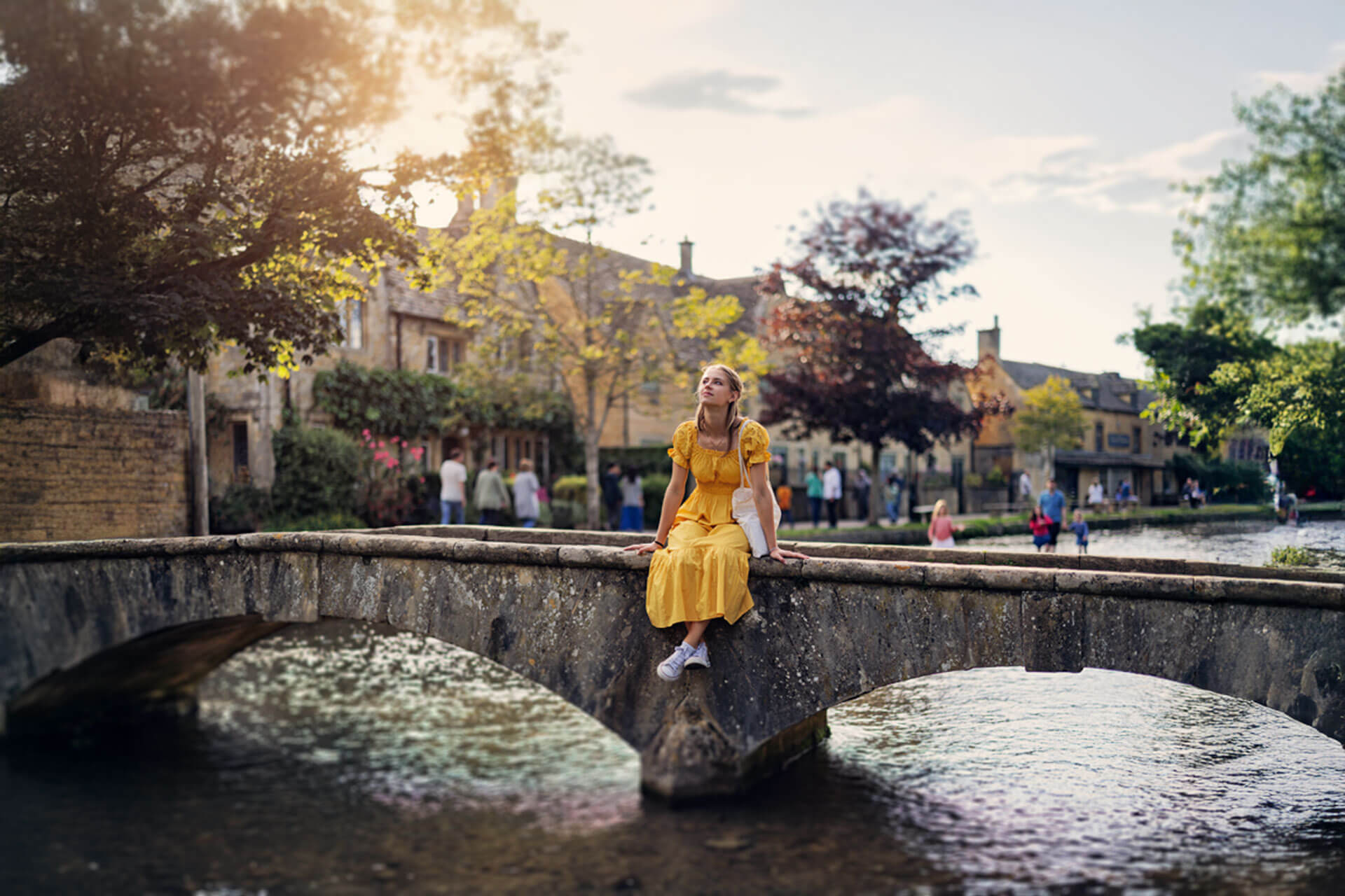 Sprachschülerin sitzt auf einer Steinbrücke und genießt ihre Englisch Sprachreise in England