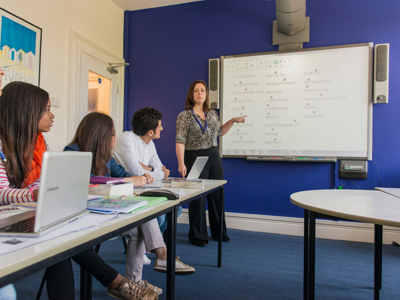 Lehrerin erklärt Vokabeln im interaktiven Unterricht an der Tafel