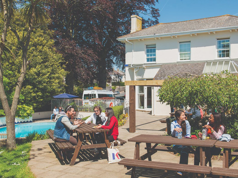Lernende genießen die Pause im sonnigen Garten der Sprachschule