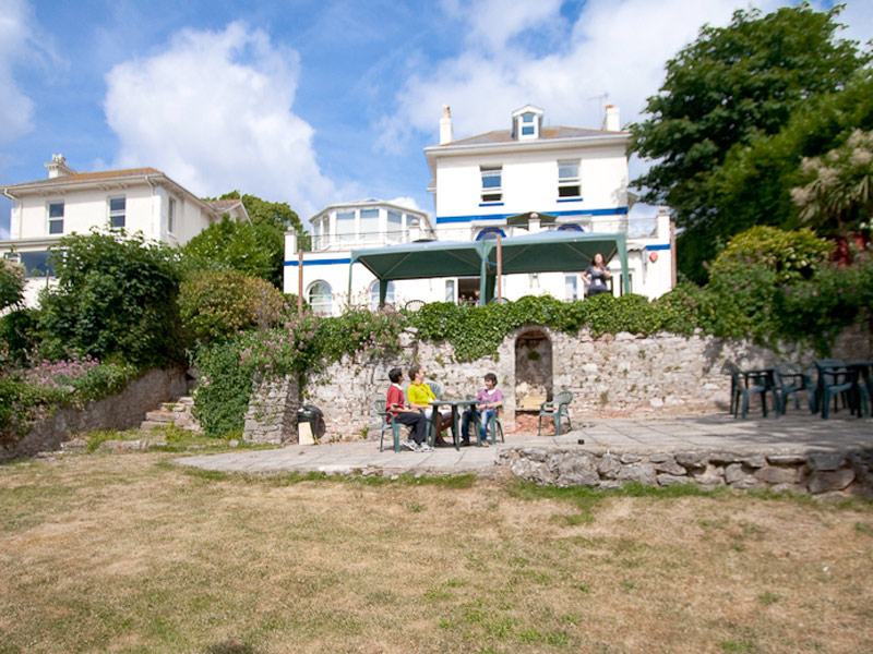 Teilnehmende genießen die Sonne im Garten der Sprachschule