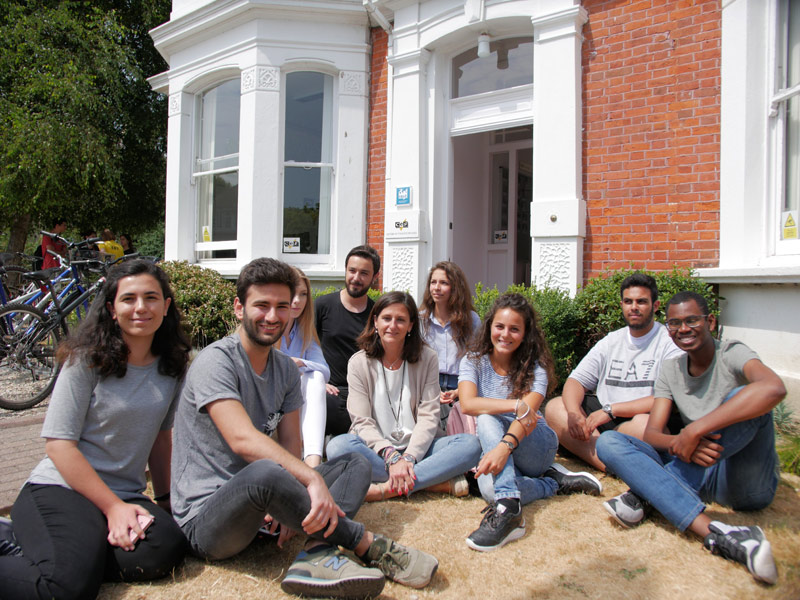 Teilnehmende einer Sprachreise sitzen gemeinsam vor der Sprachschule CES Worthing