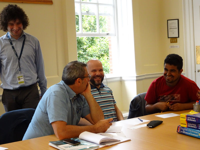 Lehrkraft lacht mit Teilnehmenden während einer Unterrichtssituation an der English in York Schule