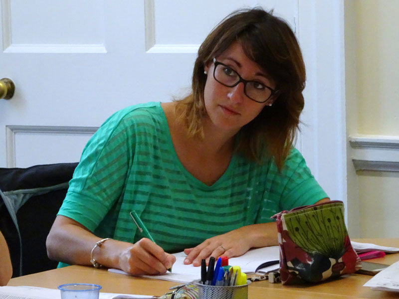 Sprachschülerin schreibt konzentriert Notizen während des Unterrichts