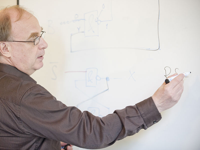 Lehrkraft erklärt Unterrichtsinhalte an der Tafel in einem Schulungsraum