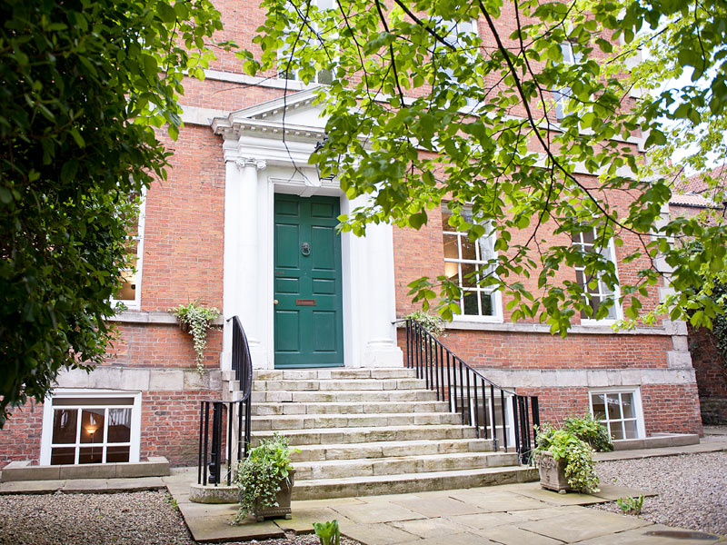 Eingangsbereich der York Associates Sprachschule in einem historischen Backsteingebäude mit grüner Tür