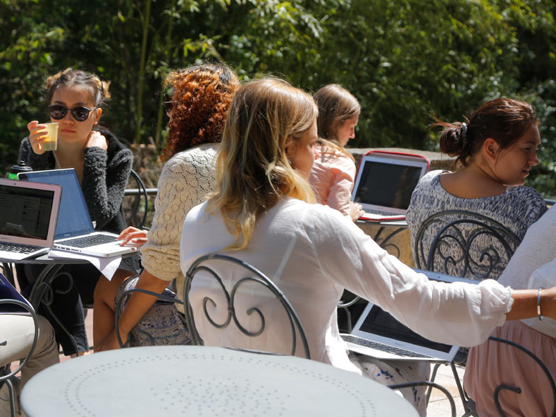 Sprachschüler lernen im Garten der IS Aix-en-Provence unter schattigen Bäumen