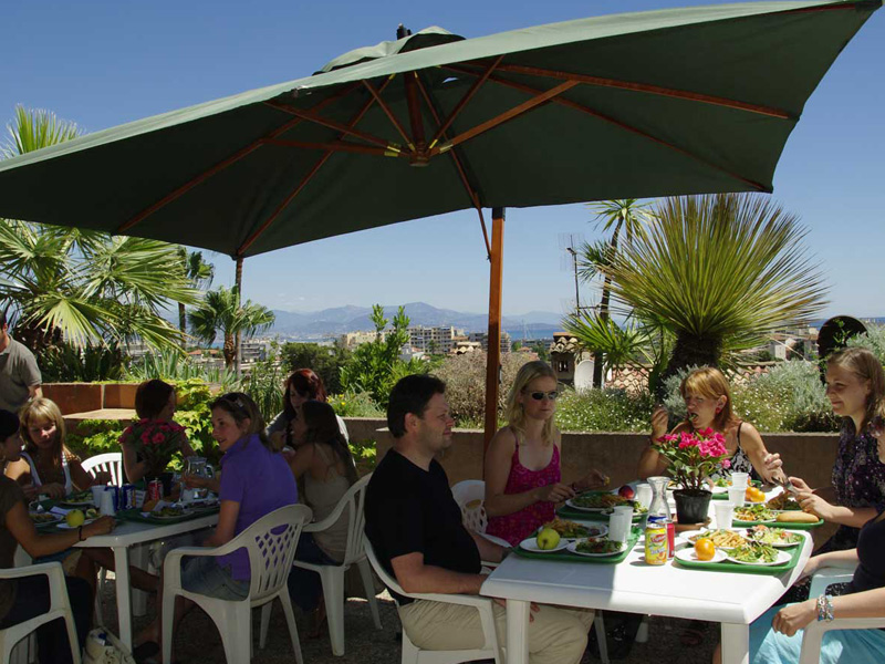 Sprachschüler essen gemeinsam auf der Terrasse der CIA Antibes mit Meerblick