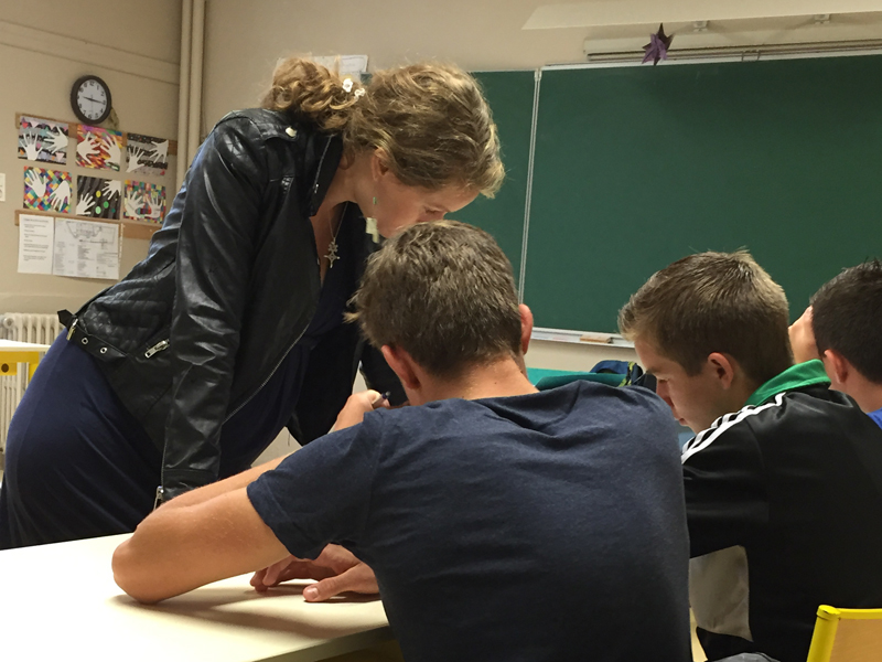Lehrerin hilft Schülern im Klassenzimmer der Sprachschule in Biarritz